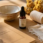 Huile essentielle d’hélichryse, bienfaits pour la circulation, verre et fleurs d’immortelle italienne
